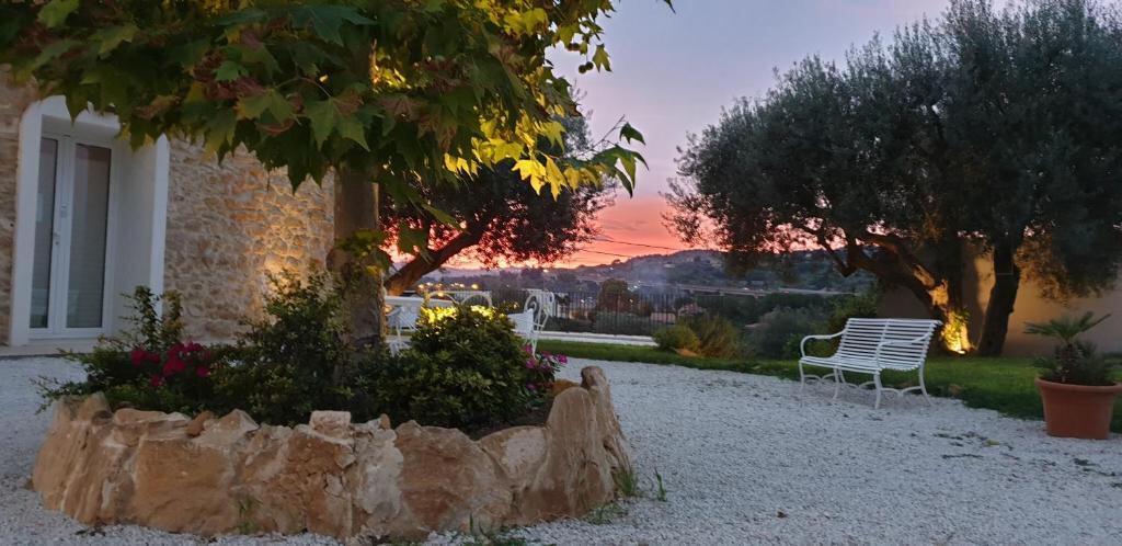Garden of Uliwood at sunset with olive trees and a bench