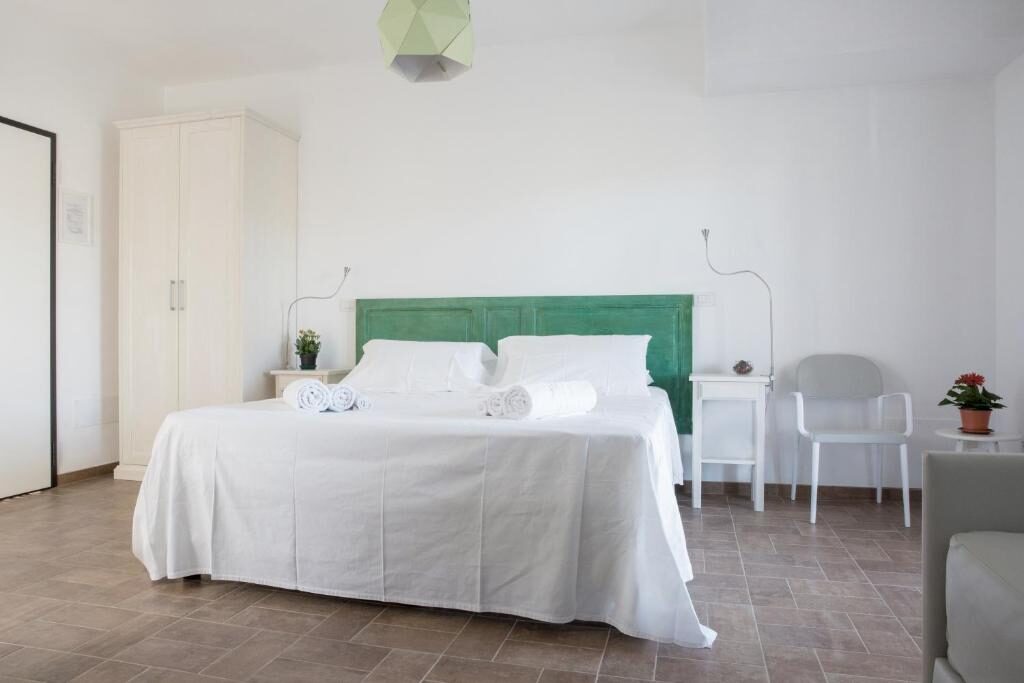 Spacious room with green headboard and white furnishings at Uliwood