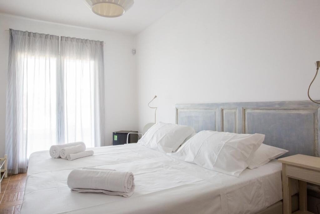 Double bed with white linens and a pale blue headboard at Uliwood